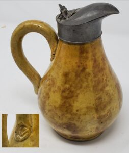 Whitewater Pitcher with pewter spout and lid, 5 3/4" tall. Sponged Rockingham manganese decoration over yellow base glaze. The diamond-shaped impression at the base of the handle terminations resembles a Masonic insignia. A Masonic Lodge was located close the the Fremont Pottery in the 1850's. This piece was originally collected in the 1940's by Joseph Thiele. Private collection.