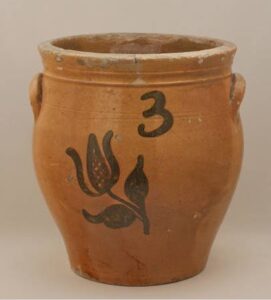 Whitewater 3-gallon cream pot with lead glaze inside and out, ear handles and manganese tulip flower decoration. Private collection.