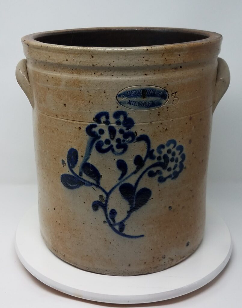 Salt glazed crock with cobalt floral motif applied using the slip cup technique. String-tie rim finish and incised stamp and capacity.