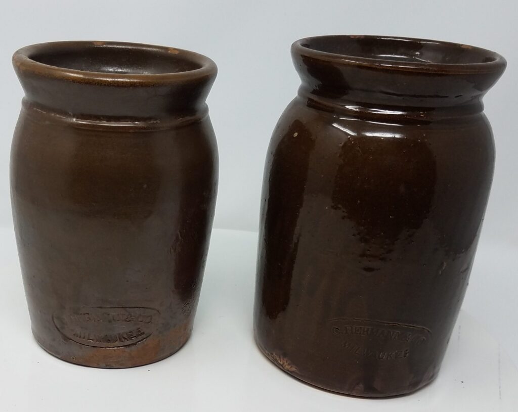 Albany slip on the inside and outside. Hermann must have made these jars in the tens of thousands based upon the number of surviving examples.  Held preserves, mustards and other condiments as well as snuff.  These two have internal shelves to support lids.