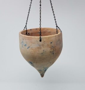 Small (5" diameter) unglazed hanging teardrop flowerpot with original chain. It has traces of blue paint added by the buyer. Small original drain hole in the tip of the bottom point. Private collection.