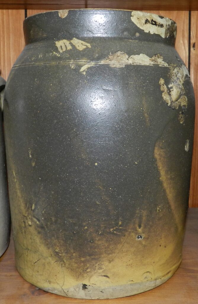 Earthenware jar with lead glaze and a shelf for lid and stamped "W.D. MOSIER". It has incised lines at the shoulder.