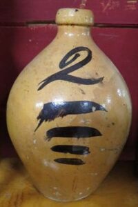 Whitewater two-gallon jug with clear lead glaze. It has a large brushed "2" over four lines, The highly ovoid form suggest it is a Fremont Pottery product. Private collection..