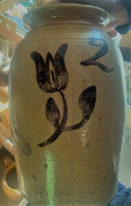 Whitewater two-gallon jar with a clear lead glaze, no handles, one incised line, and a manganese tulip decoration with two leaves on the stem and a painted "2". This piece is probably from the Whiton Street pottery. Private collection.